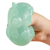 Green MushyKinz Jelleez cow squishy compressed in a hand