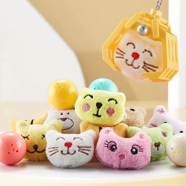 Close-up of My Kawaii mini claw machine plush toys with yellow claw lifting a smiling cat plush on white background