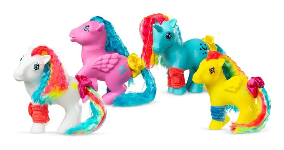 Four My Little Pony Totally Rad ponies in white, pink, blue and yellow with rainbow hairstyles, colourful legwarmers and hair accessories.