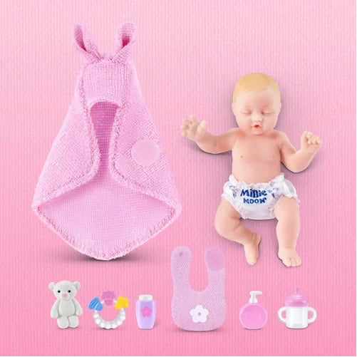 My Mini Baby newborn beside pink swaddle, teddy, bottle, bib, teether and feeding accessories