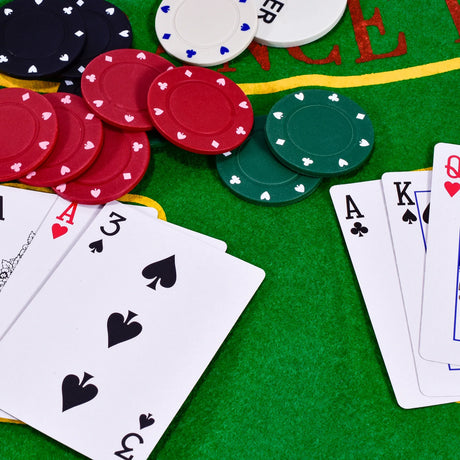Close-up of M.Y poker chips and playing cards on green felt mat Ireland