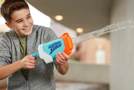 Child holding a NERF Super Soaker Torrent water blaster with a visible water stream