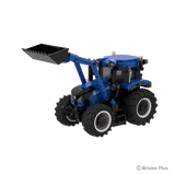 BRIXIES Plus New Holland T6.180 tractor viewed from the left side with the front loader raised, black bucket, blue bonnet and enclosed cab visible