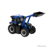 BRIXIES Plus New Holland T6.180 tractor viewed from the right side with the raised front loader, black bucket, blue bodywork and large rear tyre visible