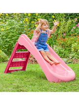 Child seated on the pink and redfolding first slide on grass