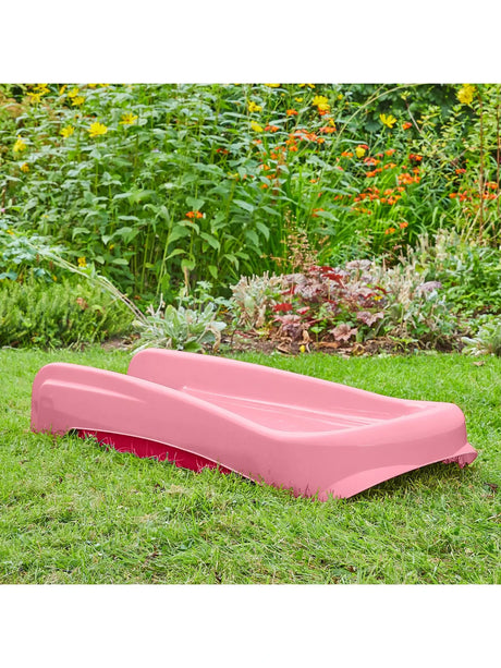 Angled view of the pink and redfolding first slide on grass