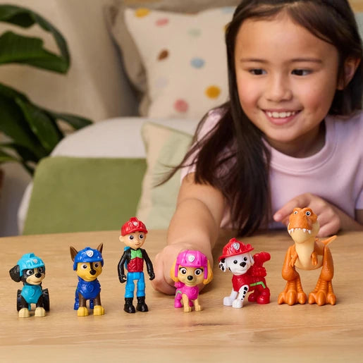 Child arranging six PAW Patrol Dino Adventure figures on a table