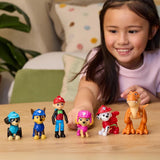 Child arranging six PAW Patrol Dino Adventure figures on a table