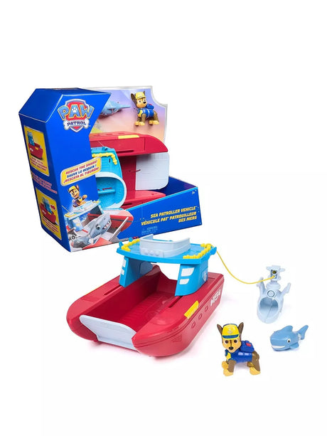PAW Patrol Sea Patroller Vehicle shown out of box alongside packaging, with Chase figure, shark rescue cradle accessory and small shark figure included