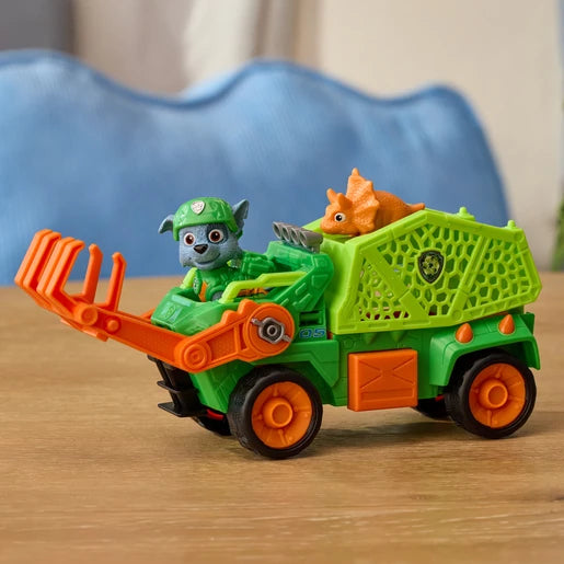Rocky seated in the green Dino Rescue Recycler with an orange dinosaur figure in the rear basket