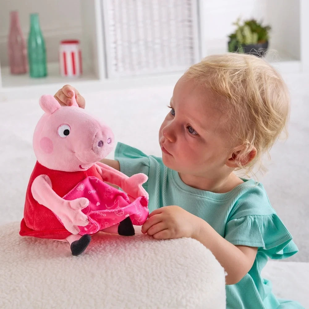 Child beside Peppa Pig soft toy with the pink blanket resting across Peppa's lap