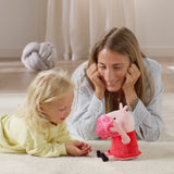 Child and adult lying on the floor beside Peppa Pig soft toy holding the pink blanket