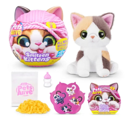 Pets Alive Smitten Kittens Series 2 calico plush kitten with green eyes beside pink capsule, yellow kinetic sand, milk bottle, sticker sheet and leaflet on white background