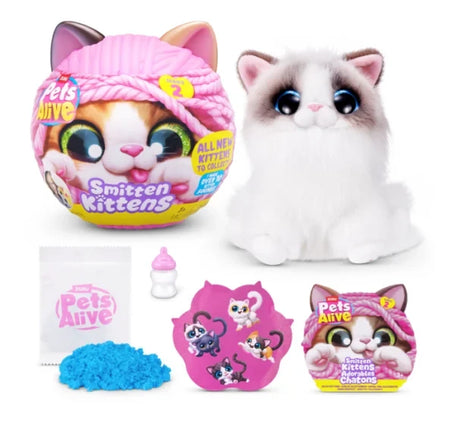 Pets Alive Smitten Kittens Series 2 brown and white plush kitten with blue eyes beside pink capsule, blue kinetic sand, milk bottle, sticker sheet and leaflet on white background