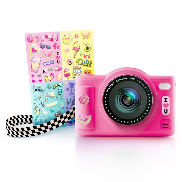 Front view of the pink Photo Creator Pop Colour Digital Camera showing its large circular lens, flash and grip, with colourful sticker sheets and a black and white chequered wrist strap behind it.