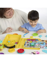 Child using the Play-Doh Disney Junior Shape A Story playset with open case, scene board and moulded shapes