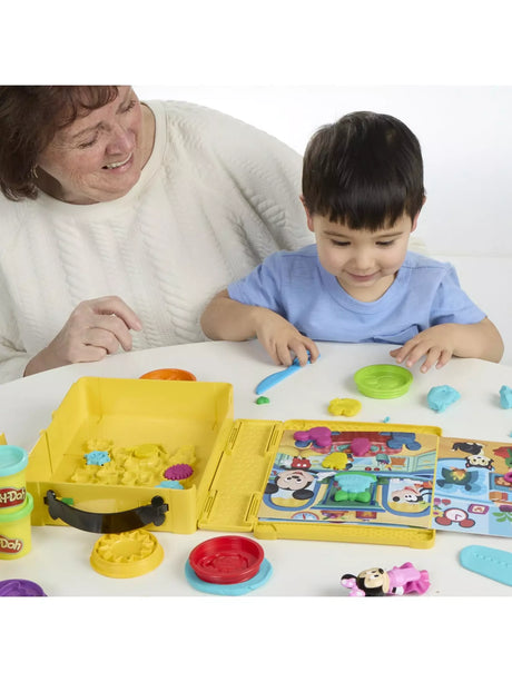 Child using the Play-Doh Disney Junior Shape A Story playset with open case, scene board and moulded shapes