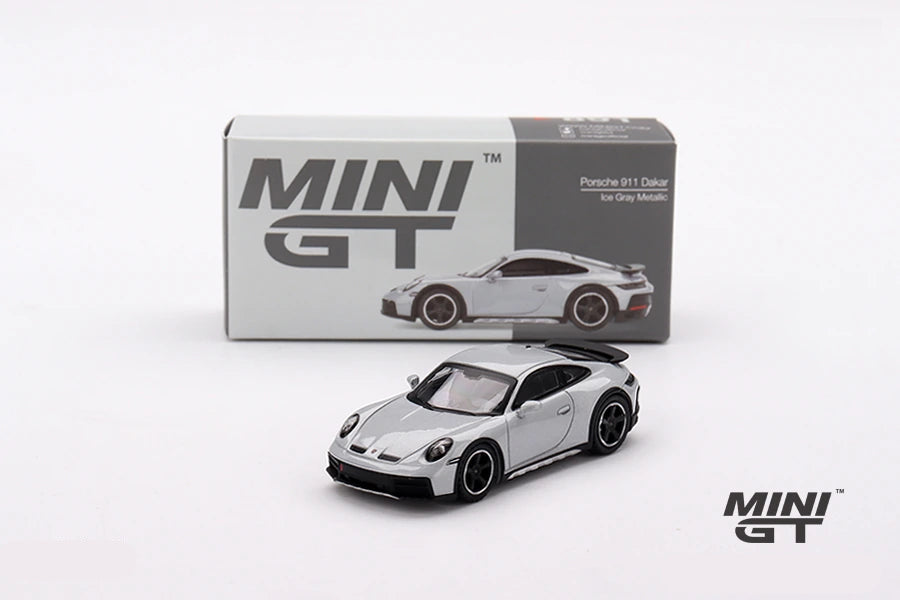 Mini GT Porsche 911 Dakar Ice Grey Metallic model displayed in front of its grey Mini GT box with the car pictured on the packaging