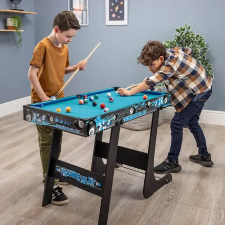 Two children playing on a folding pool table with blue playing surface