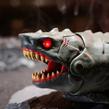 Close-up of the grey Primal Hatch Megalodon shark's head showing a glowing red eye, scar markings, open jaws, pointed yellow teeth and red mouth interior.