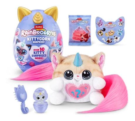 Purple Rainbocorns Kittycorn Surprise egg with gold ears and horn beside beige plush kittycorn with blue horn and long pink tail, small purple comb, Boo-Boocorn capsule and accessory packet on white background