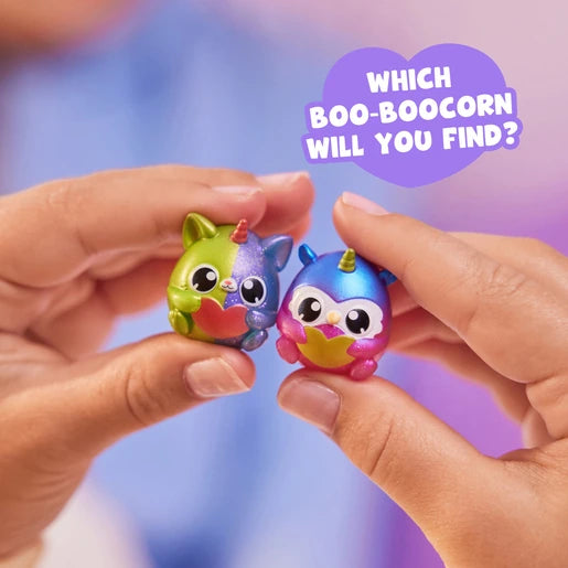 Hands holding two small Boo-Boocorn figures