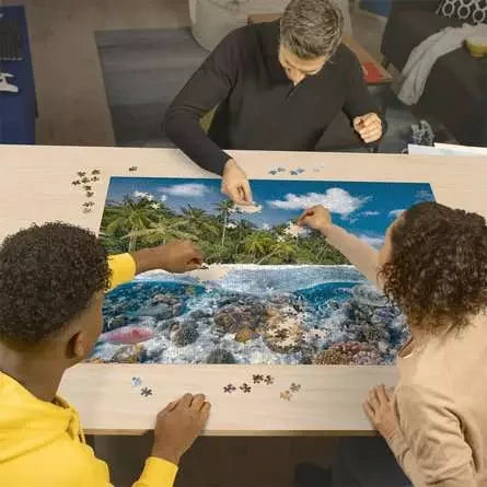 Three people building the Ravensburger A Dive in the Maldives 2000 Piece Jigsaw Puzzle