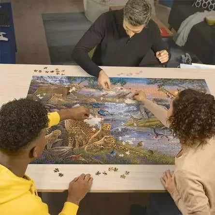 Three people building the Ravensburger Animal Kingdom 3000 Piece Jigsaw Puzzle