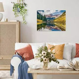Completed Ravensburger Aspen Colorado puzzle displayed on a living room wall above a white sofa