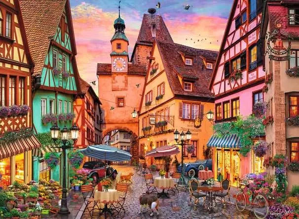 Ravensburger Bavaria Illuminated puzzle artwork showing a colourful Bavarian street with half timbered buildings, café tables, bicycles and flowers