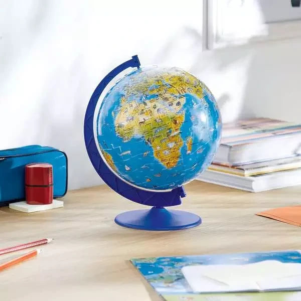 Ravensburger Children’s World Map 3D Puzzle globe displayed on a desk beside books, pencils and stationery