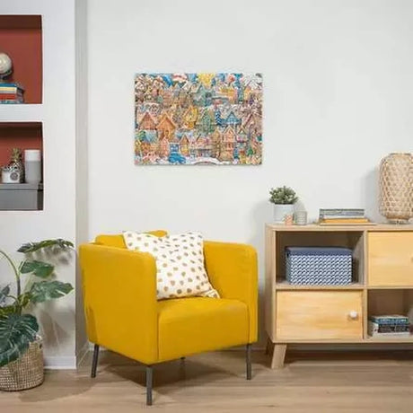 Completed Ravensburger Christmas Cookie Village puzzle displayed on a wall above a yellow armchair