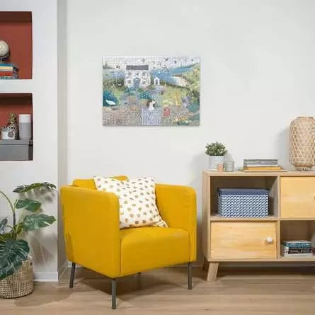 Ravensburger Coastal Cottage completed puzzle displayed on a wall above a yellow armchair and wooden cabinet