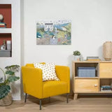 Ravensburger Coastal Cottage completed puzzle displayed on a wall above a yellow armchair and wooden cabinet
