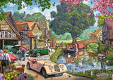 Ravensburger Days Gone By puzzle artwork showing a nostalgic village beside a river with vintage cars, canal boat, stone bridge, swans and ducks