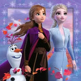 Frozen 2 puzzle artwork with purple snowflake border showing Anna in her travel cloak, Elsa in her ice-blue dress, and Olaf among autumn leaves