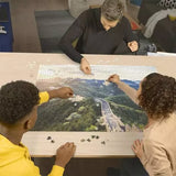 Ravensburger The Great Wall of China 2000 Piece jigsaw puzzle being assembled by three people on a table