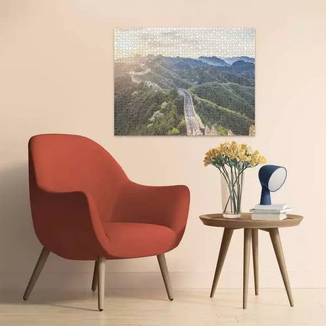 Completed Ravensburger The Great Wall of China jigsaw puzzle displayed on a wall above a chair and side table