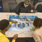 Three people building the Ravensburger Iguazu Waterfall 2000 Piece Jigsaw Puzzle