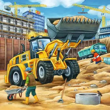 Yellow wheel loader on a construction site with workers and cranes in the background