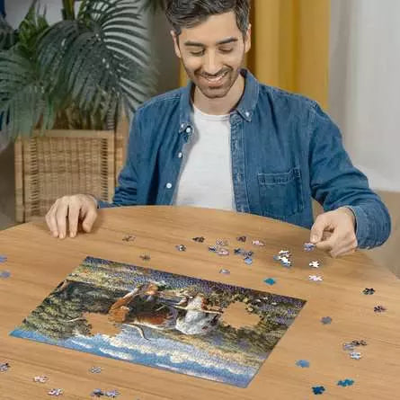 Person building the Ravensburger Longhorns 500 piece puzzle on a wooden table