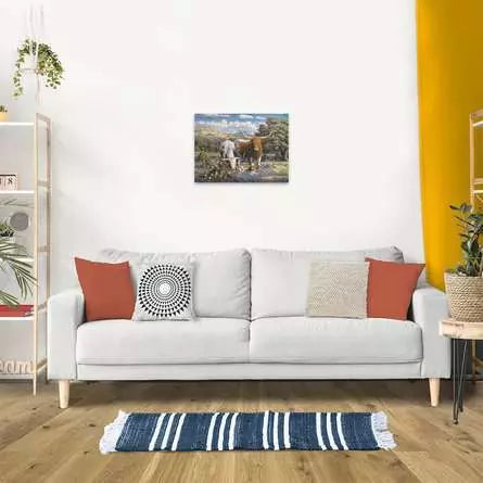 Finished Ravensburger Longhorns puzzle displayed on a wall above a white sofa