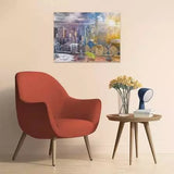 Completed Ravensburger New York Summer and Winter puzzle displayed on a wall above a red armchair and side table