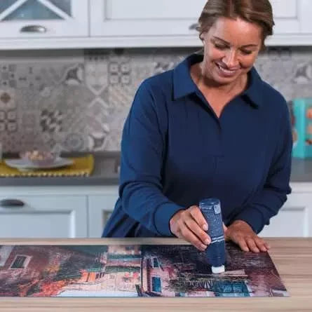 Woman using Ravensburger Puzzle Conserver on a jigsaw puzzle