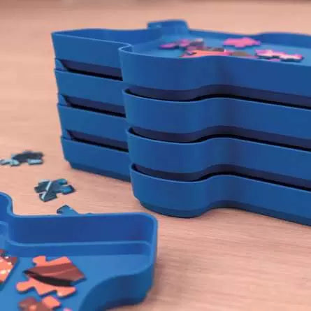 Close up of stacked blue sorting trays with jigsaw pieces