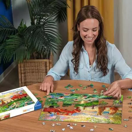Woman building the Summer Love jigsaw puzzle on a table with loose pieces around it