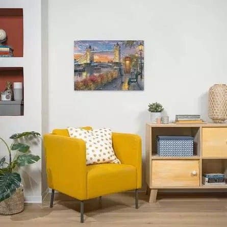Completed Ravensburger Tower Bridge at Sunset puzzle displayed on a wall above a yellow armchair and wooden cabinet