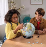 Ravensburger The World on V Stand globe puzzle shown in a warm toned indoor setting.
