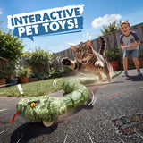 Green remote control snake moving along a garden pathway as a tabby cat leaps above it. A smiling boy holds a grey controller in the background, with the promotional heading Interactive Pet Toys.