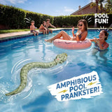 Green amphibious remote control snake swimming through a blue outdoor pool towards people in the water, including a woman sitting on a pink inflatable ring. Promotional text reads Pool Fun and Amphibious Pool Prankster.